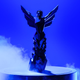 A 2021 Game Awards trophy sits on a pedestal in front of a blue background.